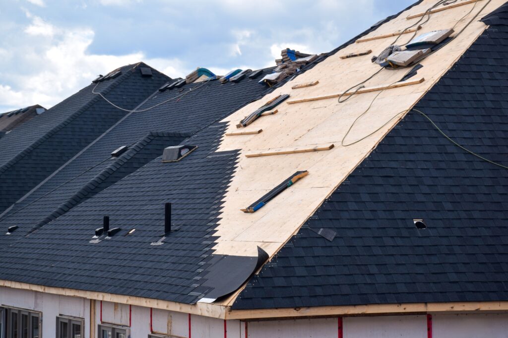 Closeup installation of black roof shingles on new residential home