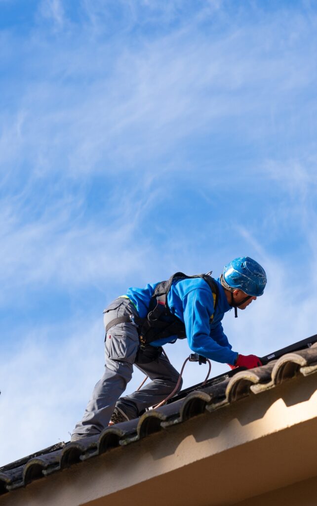 Solar panel installer working on a roof